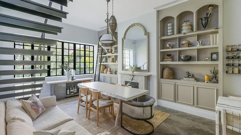The dining room features built-in shelves, a fireplace and seating.