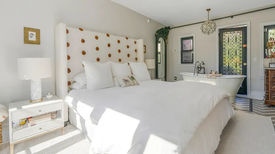 The primary bedroom has a freestanding soaking tub by the bed.
