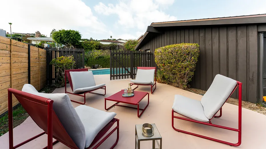 A sitting area can be found in the corner of the backyard.