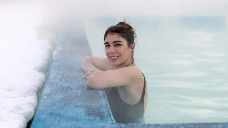 Woman soaks in snowy hot springs