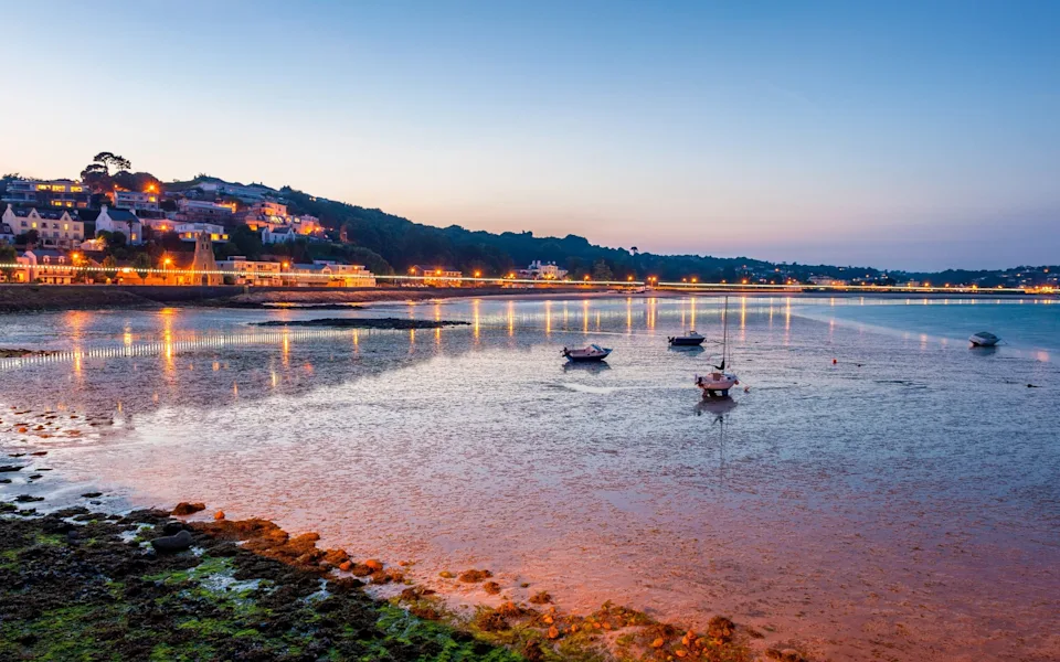 Coastline of Saint Aubin, Jersey, Channel Islands, UK at low tide and sunset