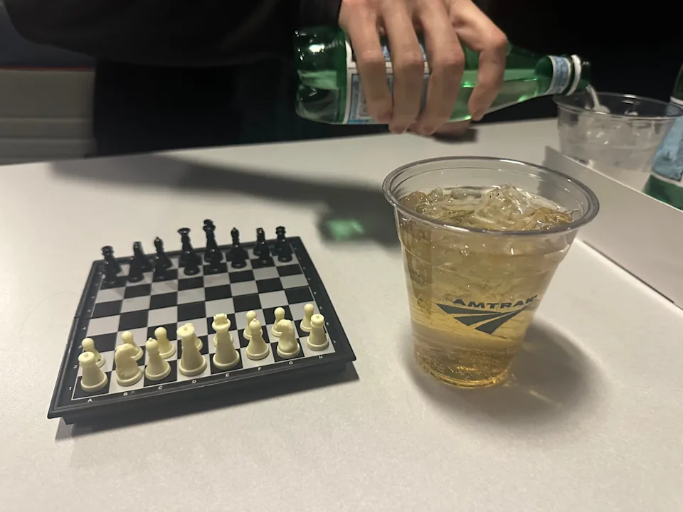 Mini chess board and a whisky soda.