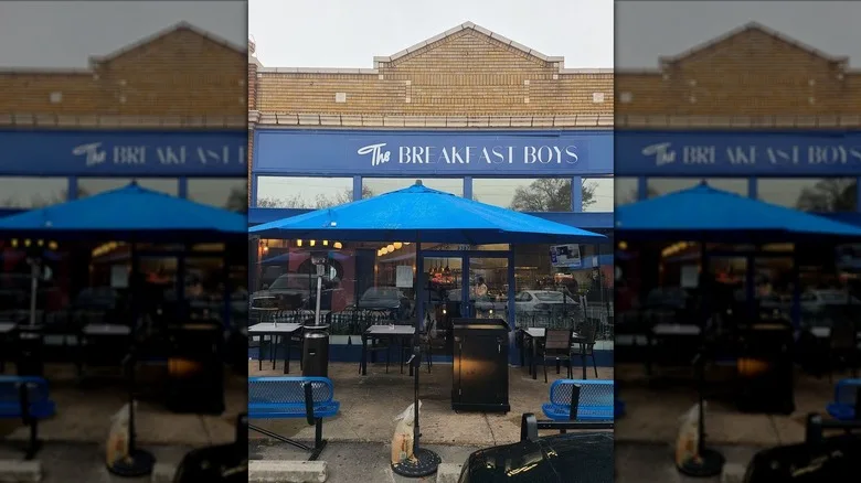 Exterior of The Breakfast Boys, including the patio with blue umbrellas
