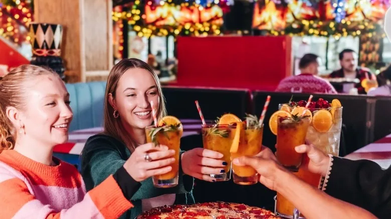Group of friends toasting the holiday season at the Santa Baby Bar.