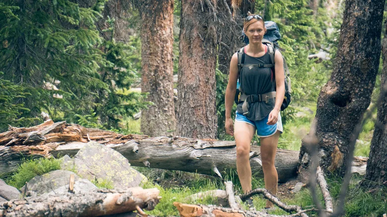 A woman with a backpack hiking through Utah's mountains