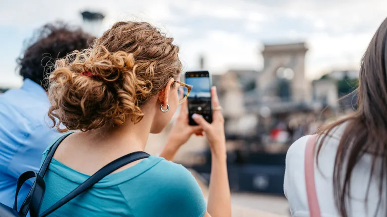 Curly haired tourist clicking a picture on her phone