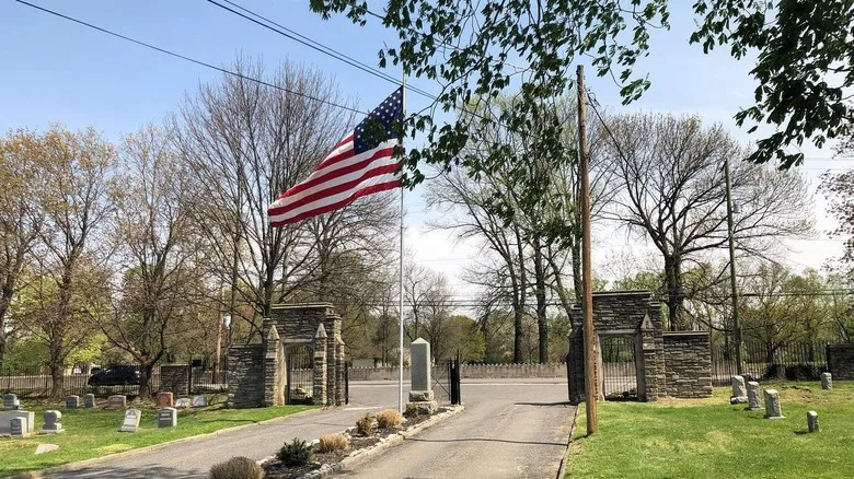 View of graves in Eden Cemetery in Collingdale, with an American flag and trees in the background
