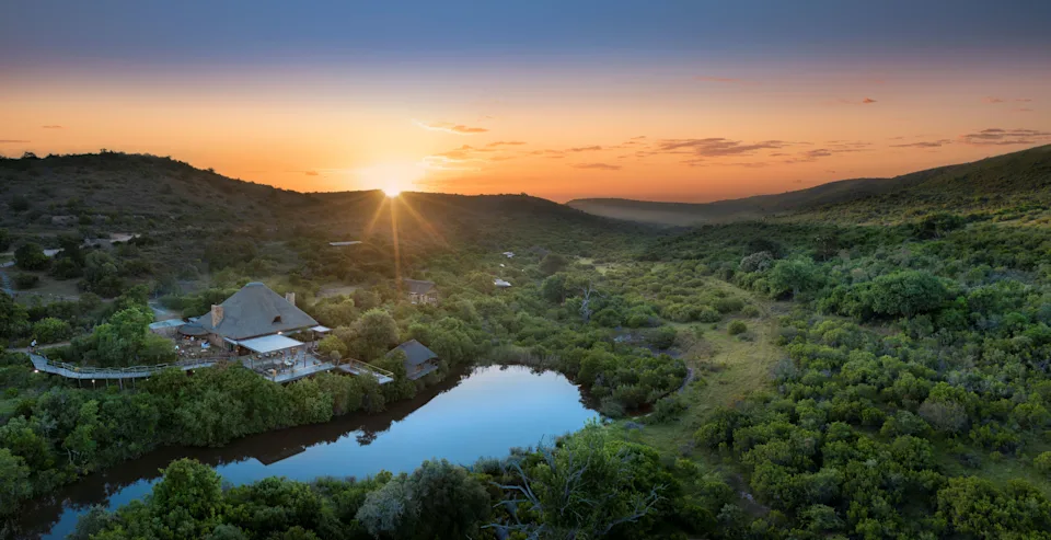 Exterior view of a Shamwari lodge set against open plains and rolling hills in South Africa’s Eastern Cape.