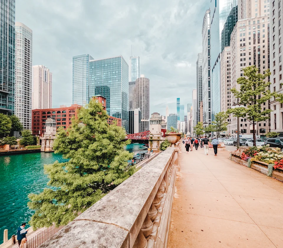 Chicago, Illinois, USA : July 30, 2025 Tourists and businesspeople stroll along the Riverwalk adjacent to the Chicago River. Views of downtown city skyline.