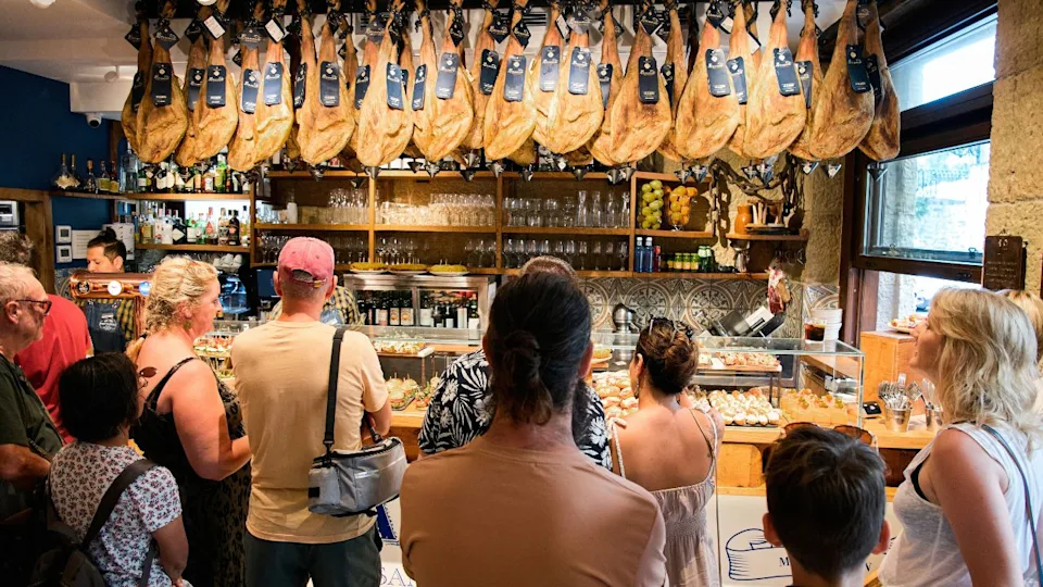 San Sebastian, Basque Country, Spain; July 28, 2023.Tourists observe the impressive bar of pintxos, and Jabugo Hams while waiting their turn to order in a bar in San Sebastián, Basque Country.