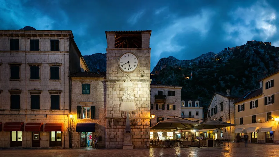 The clock tower on the army square at the entrance gate in the medieval city of Kotor. Evening view. Kotor, Montenegro
