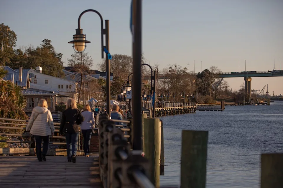 Madeline Gray/Bloomberg via Getty Images People walking along the waterfront in Wilmington, North Carolina.