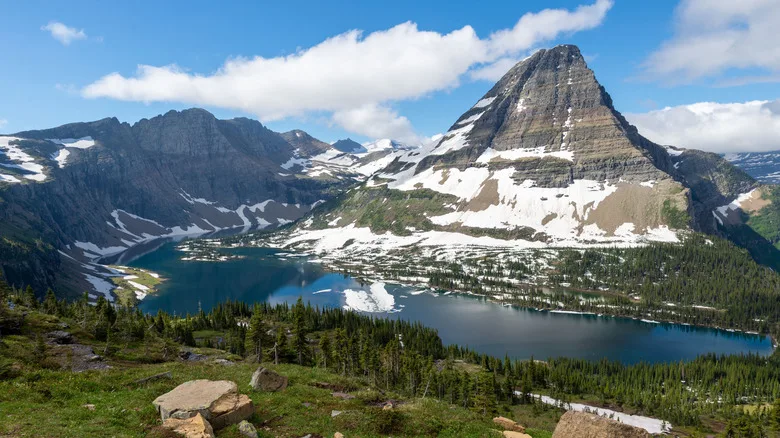 A snow-dappled mountain and lake in Glacier National Park