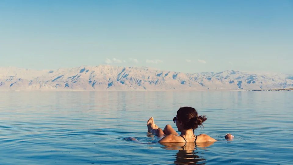 Girl is relaxing and swimming in the water of the Dead Sea in Israel