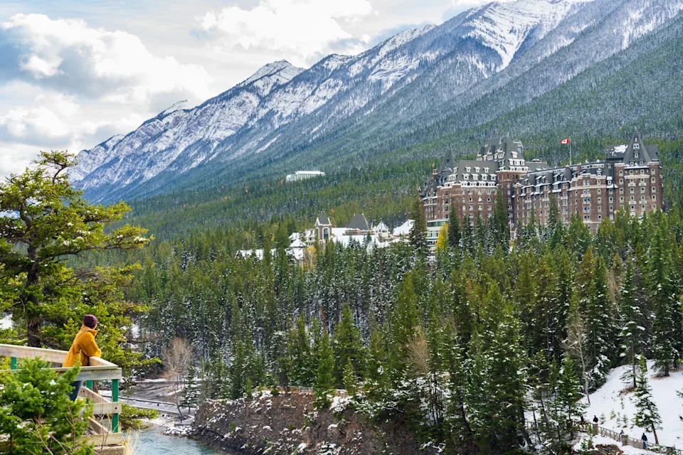 Fairmont Banff Springs and Bow River Falls in snowy autumn sunny day. View from Surprise Corner Viewpoint. Banff National Park, Canadian Rockies.