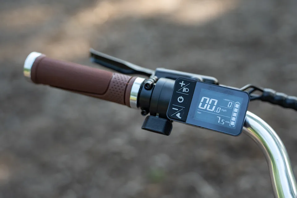 A close-up view of the Priority Glide e-bike's throttle and display screen.