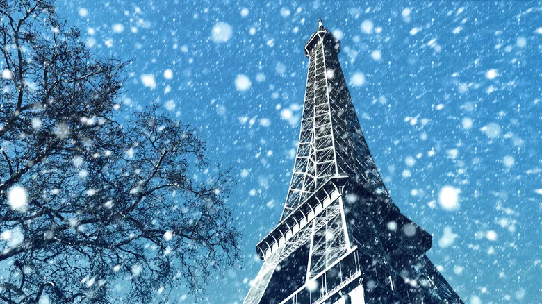 Snow falling in front of the Eiffel Tower in Paris.