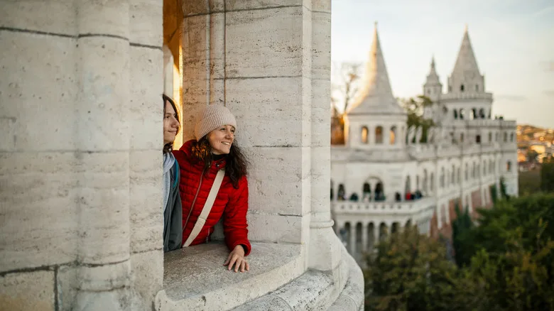 Mother and son at Fisherman's bastion in Budapest, enjoying the view, looking happy and relaxed.