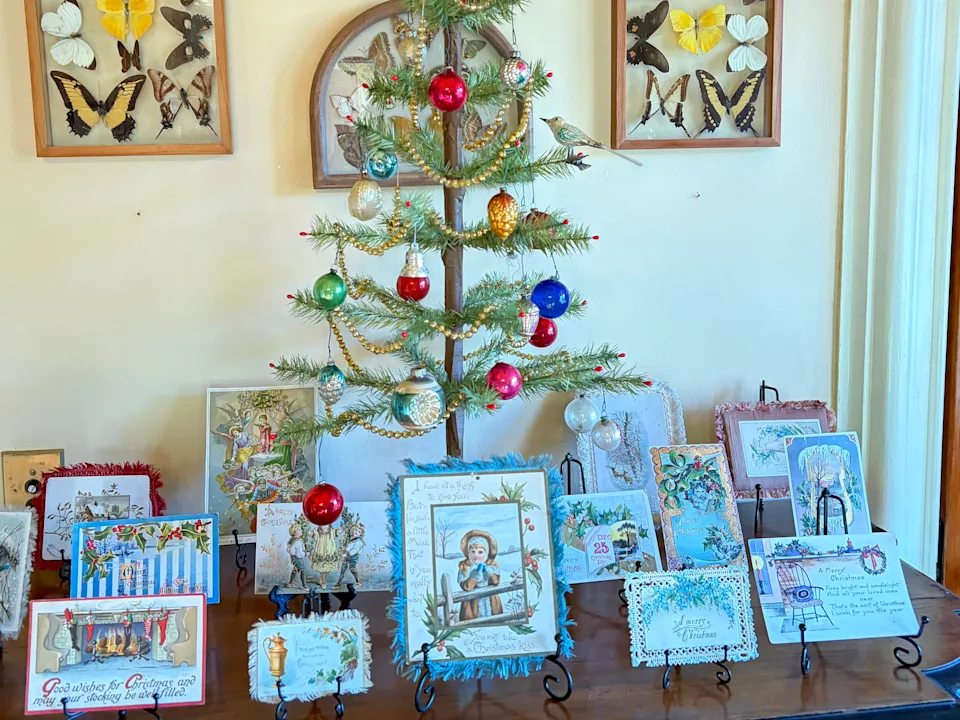 Victorian holiday cards under a Christmas tree.