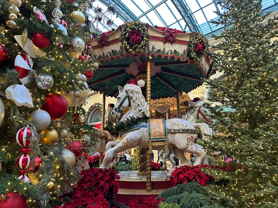 Large carousel hourse surrounded by lit-up trees with ornaments at Bellagio holiday display