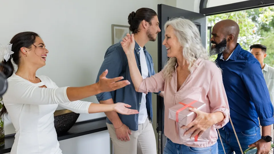 Guests arriving with gifts, warmly greeting bride at home during wedding celebration. hospitality, reception, ceremony, gathering, presents, festivities