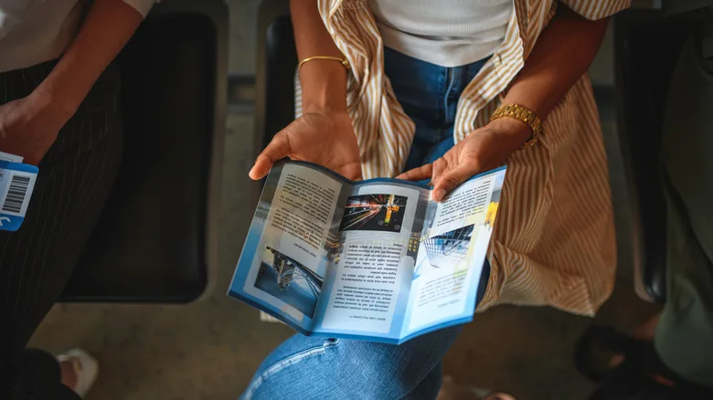 Woman in a striped shirt reading a travel brochure