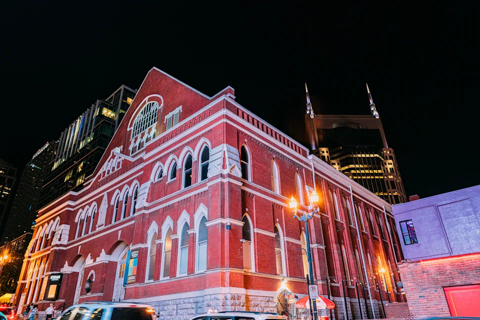 Vibrant-Colored neon lights on a busy night at the bars and honky-tonks illuminate the Ryman Auditorium just off Broadway, the tourism center of Downtown Nashville, Tennessee