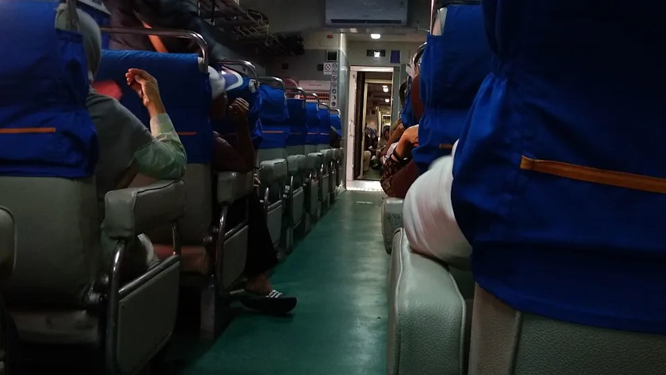 Inside of train with sitting and standing passengers
