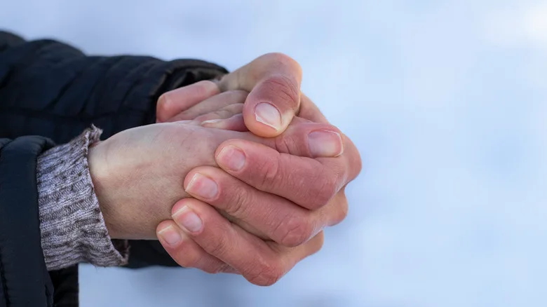 Hands clasped together against a snowy background