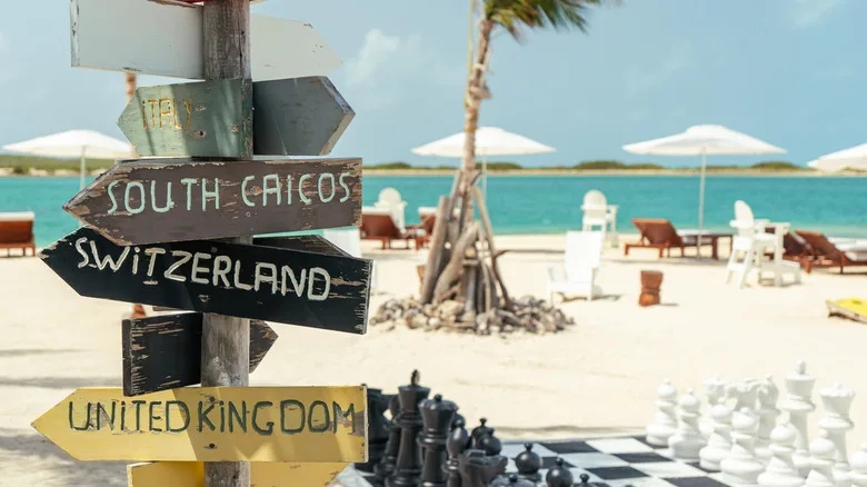 a directional sign next to yard games by the beach