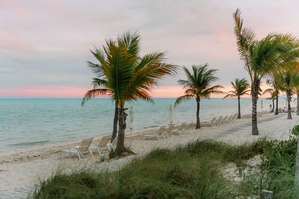 Heather Durham/Travel + Leisure Lounge chairs lay along the white sandy shores of Turks & Caicos.