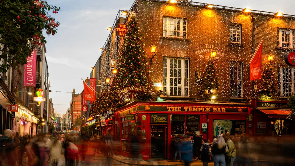 Busy street in front of Temple Bar, Dublin, adorned with festive decorations and Christmas lights