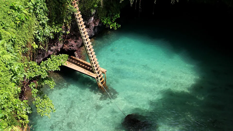 To-Sua Ocean Trench is located on the southeast coast of Upolu Island in Samoa. Its a massive swimming hole filled with blue water and surrounded by lush vegetation.