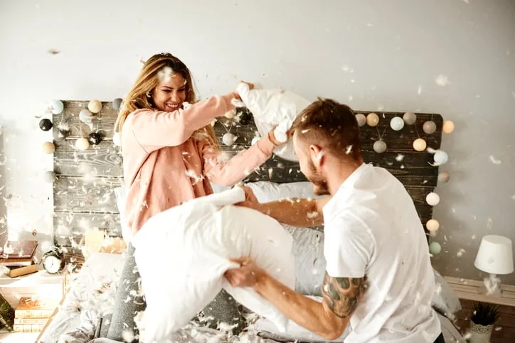 Couple having a fun while pillow fight