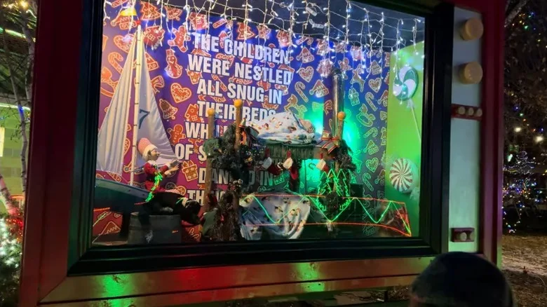 A display at Bentleyville with elves, Christmas quotes, and decorations in a giant TV