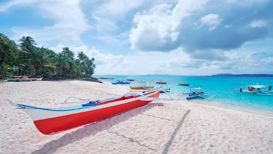 Beautiful landscape with tropical white sand beach with fishing boats. Siargao Island, Philippines.