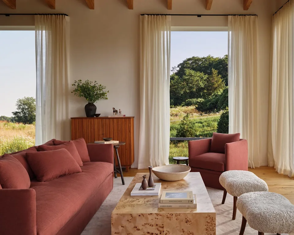 Modern living room featuring a sofa, armchair, and coffee table with natural light.