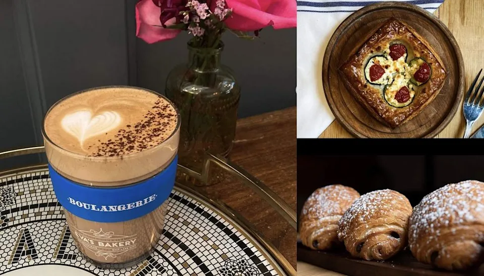 Latte, savory tart, and croissants on a table with pink flowers in the background.