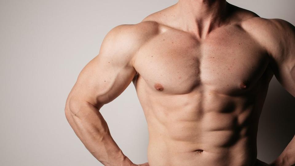Up close image of male topless showing muscles.
