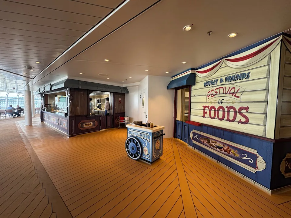 the sign entrance to mickey and friends festival of foods, with a cafeteria style venue