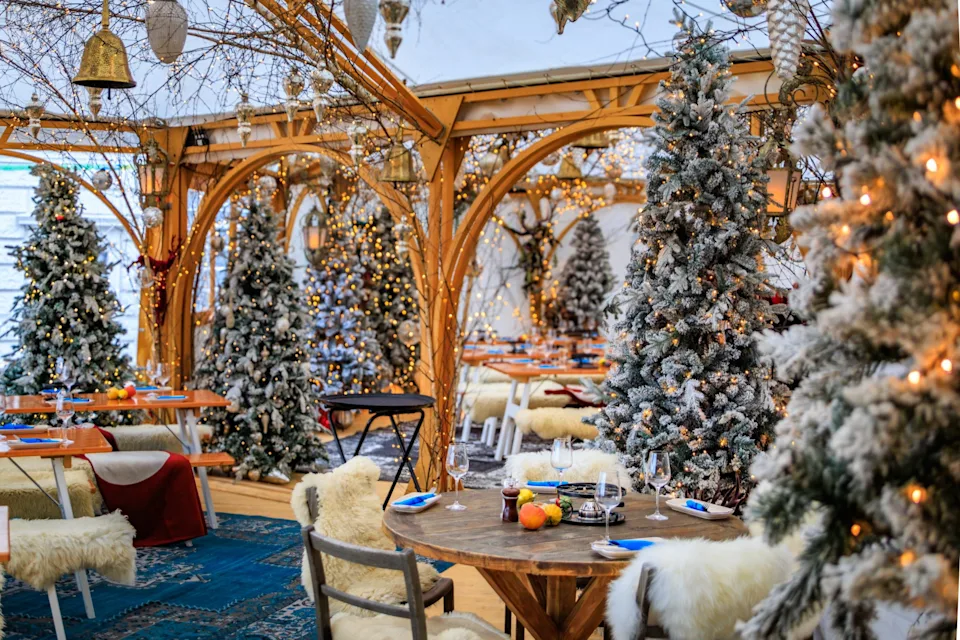 Enjoy a glühwein in an indoor winter wonderland surrounded by wooden tables, fur throws and Christmas trees