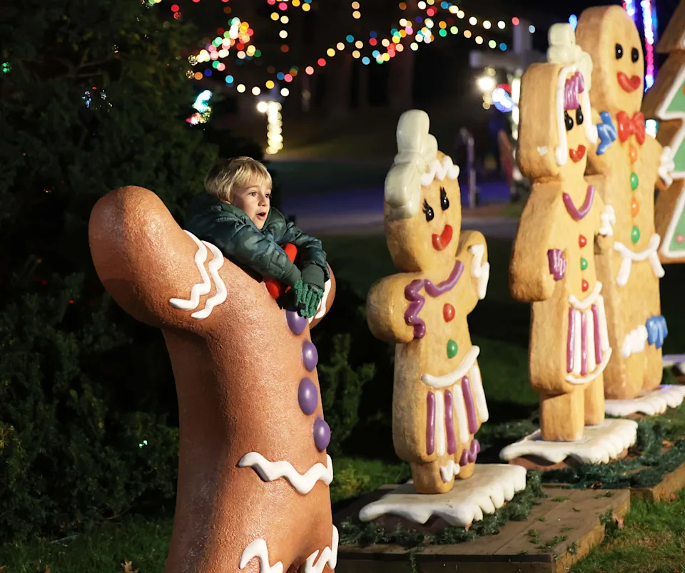 Michael Ferria of Huntington Beach, California, takes a photograph with gingerbread cutouts during Edaville's Holiday Festival of Lights in 2022 in Carver, Massachusetts.