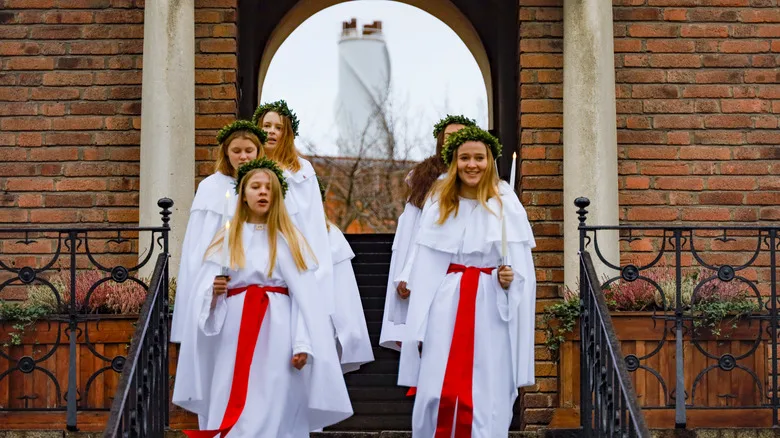 Girls singing and holding a candle during Lucia celebrations