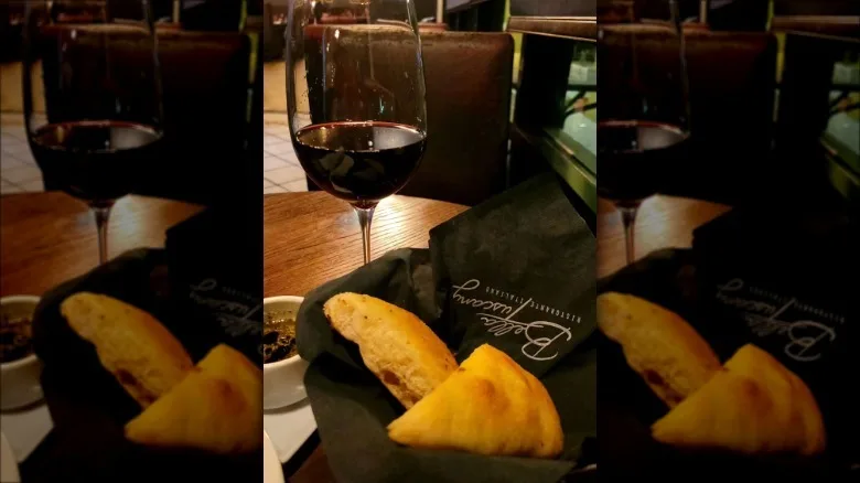 Glass of red wine and basket of bread on table at Bella Tuscany