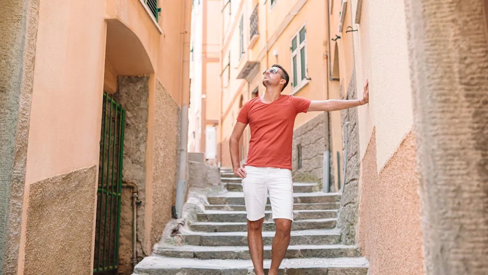 Tourist man walking on empty street In old italian village