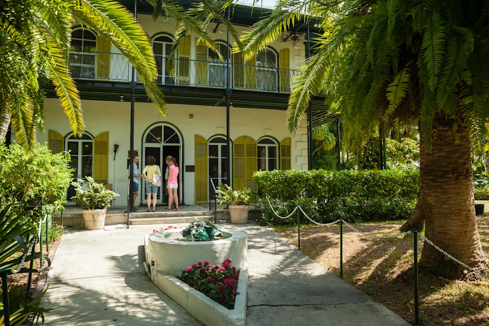 Key West, USA - March 18, 2013: Ernest Hemingway's house in Key West, Florida, USA. Tree tourists entering the home..