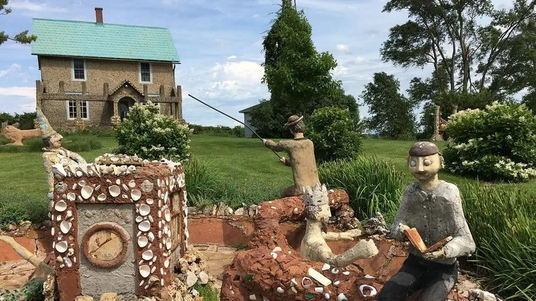 Mixed-media statues in front of a small Wisconsin farmhourse