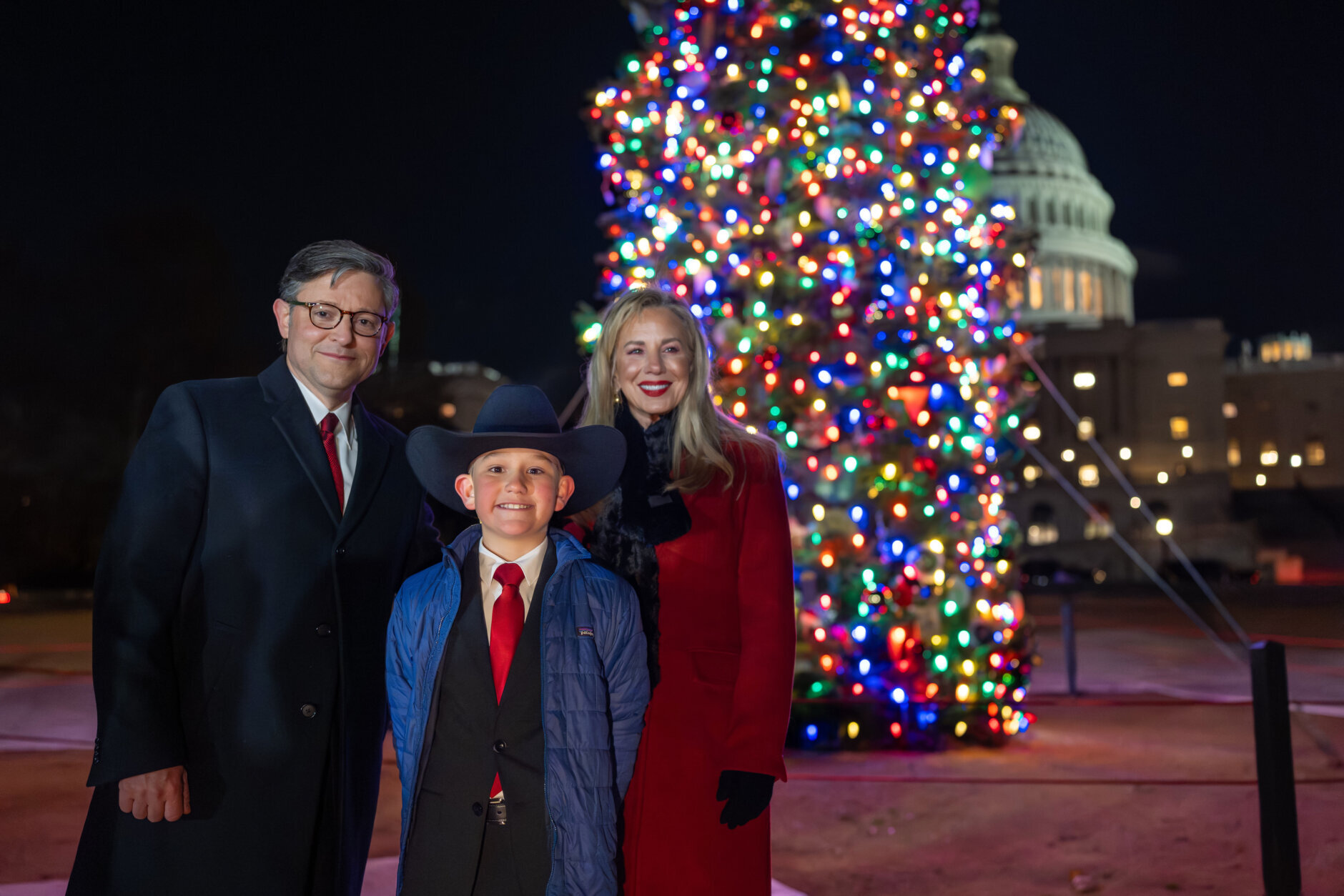 House Speaker Mike Johnson of La., and his wife Kelly Johnson, stand with Grady Armstrong, a fourth-grade student from Virginia City, Nev., as they light the Capitol Christmas tree, a red fir from the Humboldt-Toiyabe National Forest in Nevada, in Washington, Tuesday, Dec. 2, 2025. (AP Photo/J. Scott Applewhite)