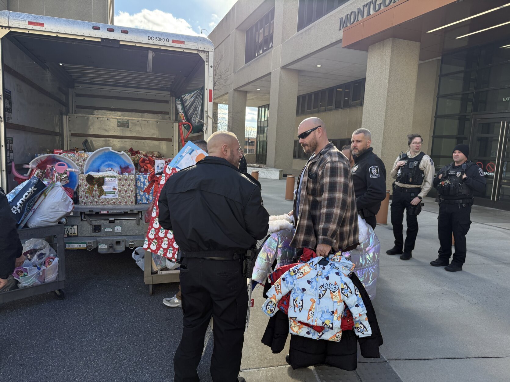 people unloading toys and clothing from box truck for holiday gift drive