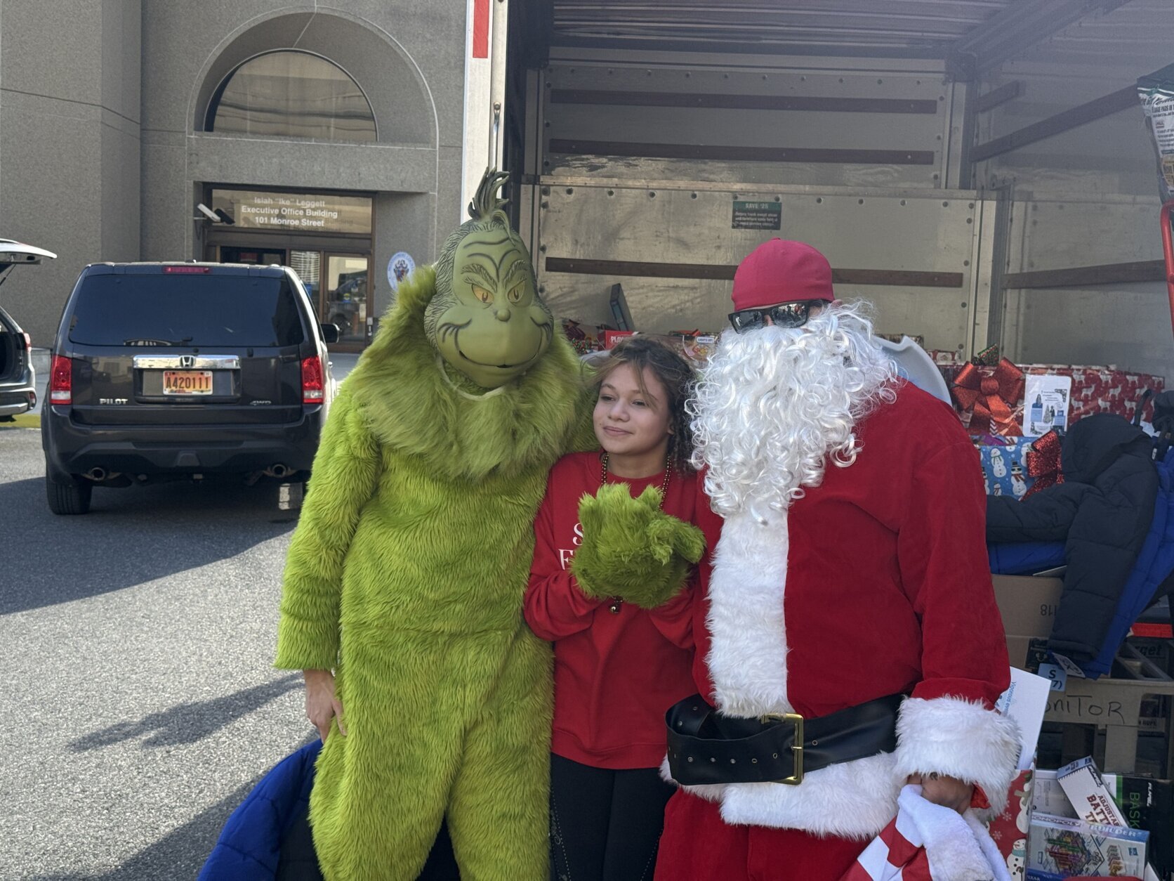 girl between grinch and santa posing for photo